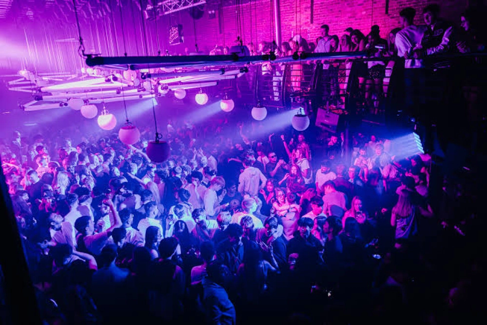 Pista de club iluminada en tonos rosa y violeta