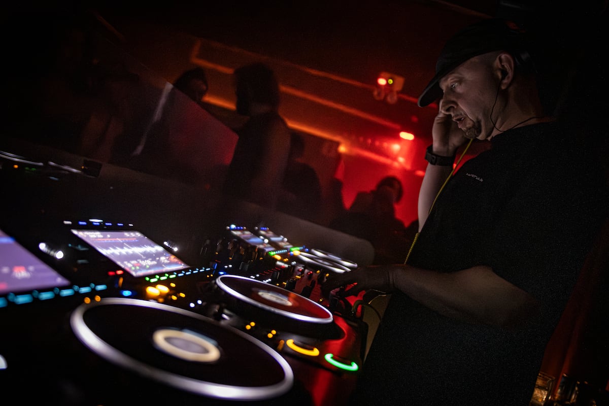DJ mezclando en una cabina iluminada en rojo